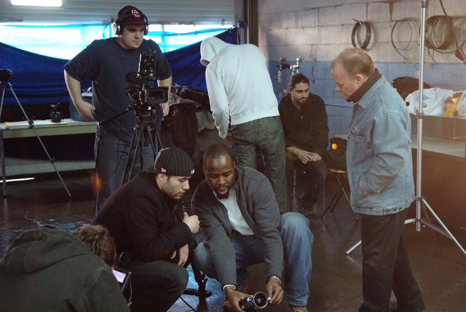 Kunle Odunewu reviewing footage with a production crew